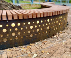 special plint med LED lys og et unikt mønster på sider fremstillet i corten stål og beklædt med mahogni staver