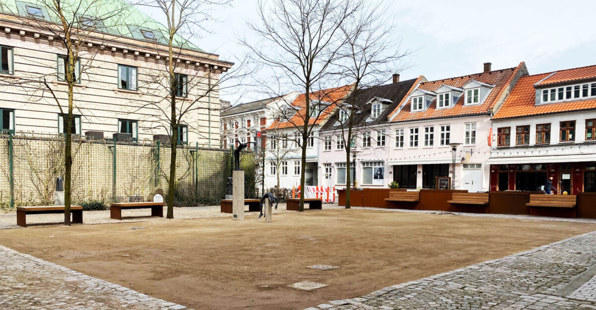 områdefornyelse af Mathilde Fibgers Have i Aarhus med By Bangs plantekummer i cortenstål med bænke monteret på sider, som er beklædt med mahogni planker