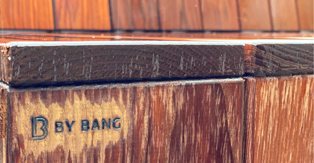 By Bangs logo på siden af den stor cirkel specialbænk lavet til skolegården på Marie Mørks Skole, med beklædning af termoask stave