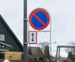 Letvægts skilteholder til lygtepæl fremstillet i varmgalvaniseret stål på gaden i Herlev Kommune