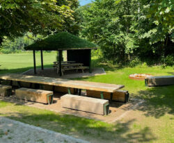 et bordbænkesæt i solidt egetræ og med metalelementer malet i grøn står i parken