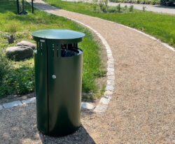 en udendørs affaldsbeholder med dobbelt sideindkast fremstillet i malet galvaniseret stål står i parken i Nørre Søby