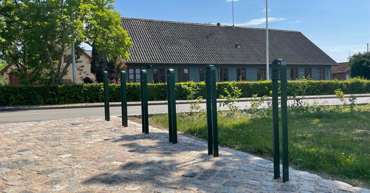 en række cykelparkerings steler fremstillet i malet galvaniseret stål står i parken i Nørre Søby