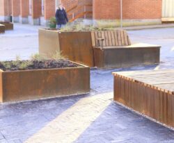 Plantekasser i cortenstål med indbyggede bænke og plads til planter, Langå by midt