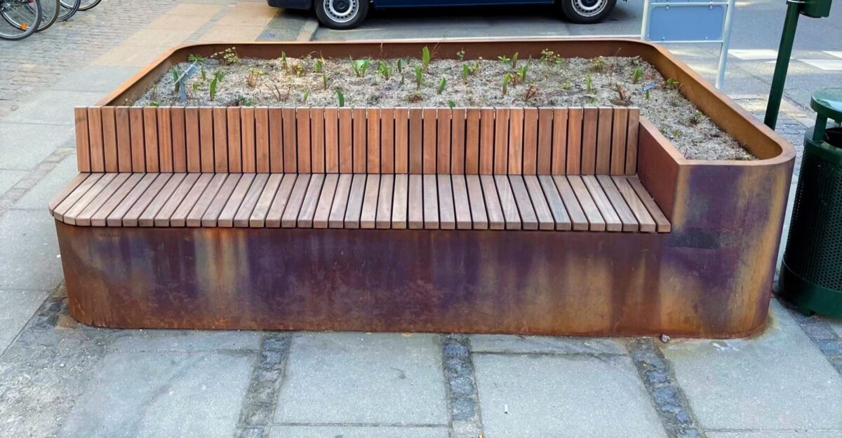 en unik plantekasse i cortenstål med en bænk af mahogni planker på Frederiksbergs gade