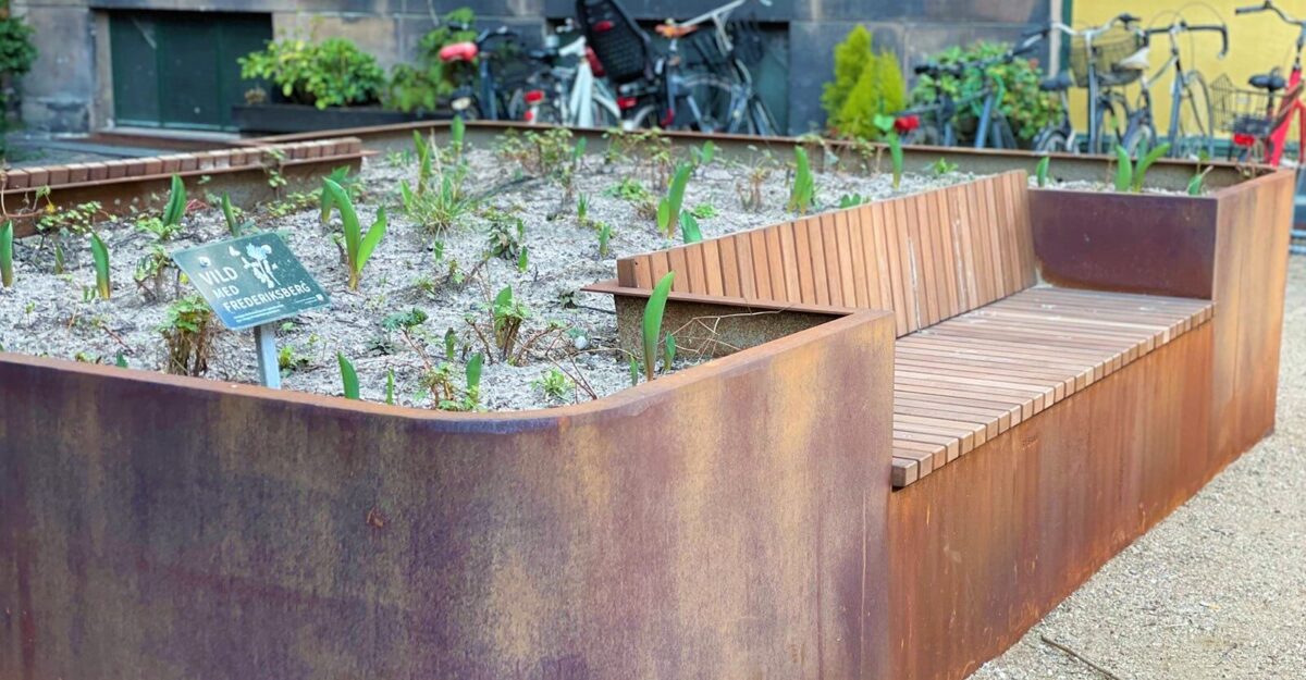 en unik plantekasse i cortenstål med en bænk af mahogni planker på Frederiksbergs gade