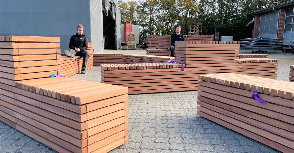 en række bænke specielt designet til dette projekt, lavet af galvaniseret stål og beklædt med mahogniplanker står i gården af By Bangs værksted til Puggaardsgade