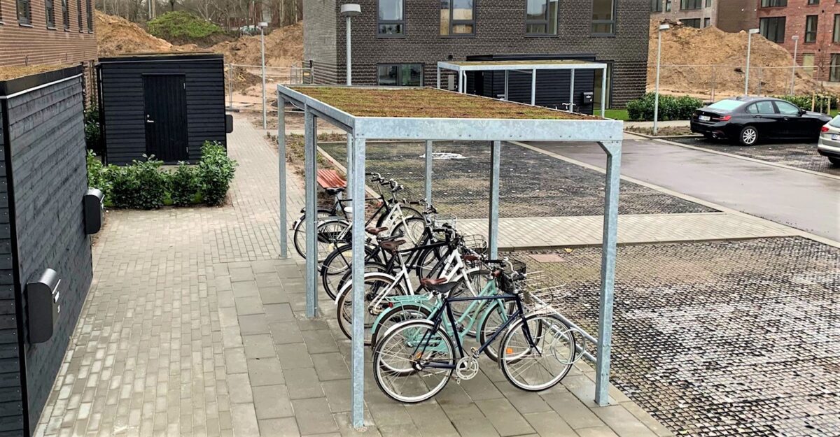 Casa 01 cykeloverdækning i galvaniseret stål med en række af cykelstativer til mange cykler og et sedum tag