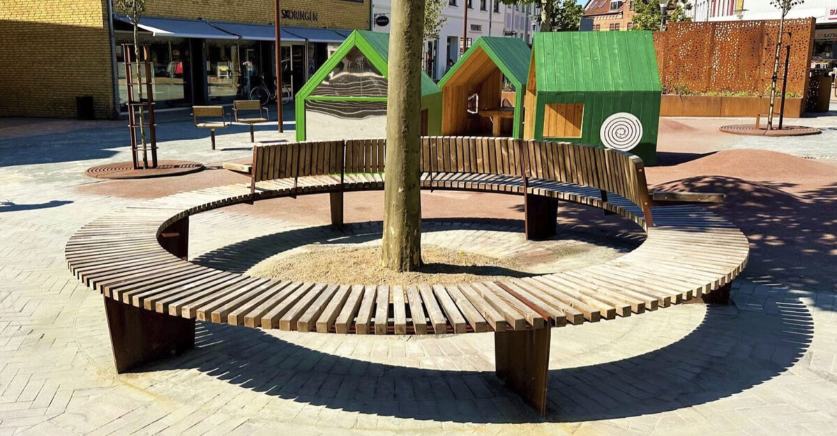 Crepa plint i cortenstål og beklædt med træ omkring et tre på Ringe Torv