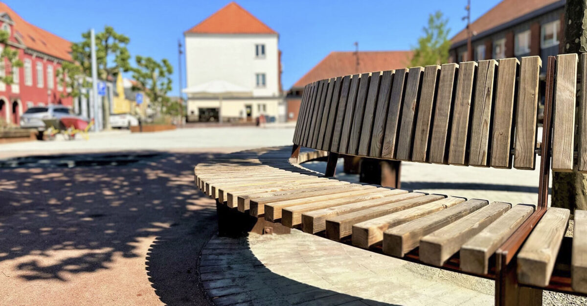 Crepa plint i cortenstål og beklædt med træ omkring et tre på Ringe Torv