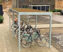 Casa 01 cykeloverdækning i galvaniseret stål med en række cykelstativer og et sedum tag