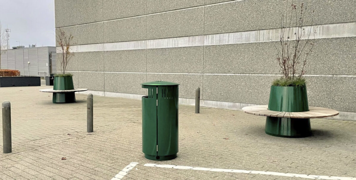 Alberi - store og høje plantekummer med runde bænke, sammen med en malet skraldespand