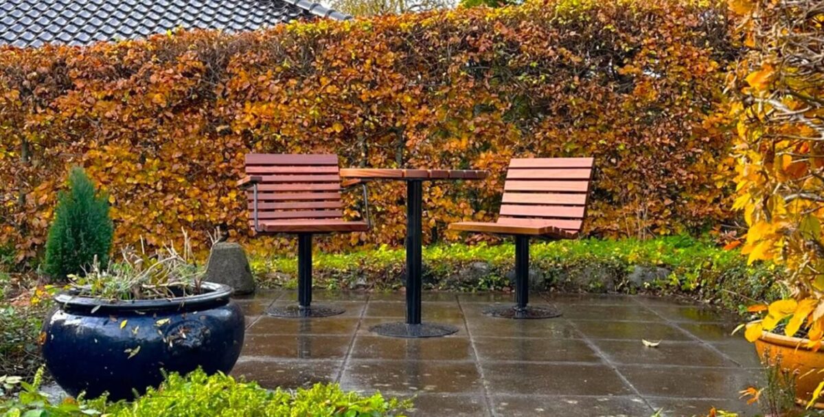 comodo udendørs cafestole og et bord beklædt med mahogni planker