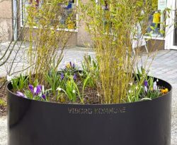 Planteringe malet i sort med et bed til blomster og planter