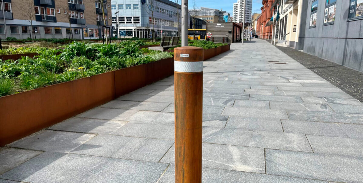 Ø108 corten pullert nedstøbt på gaden i midtbyen med hvid refleks