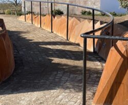 corten stensætning i 5 mm cortenstål med 452 trekantede plader og belysning danne en ny stensætning ved Elev Kirke, et moderne design fra By Bang