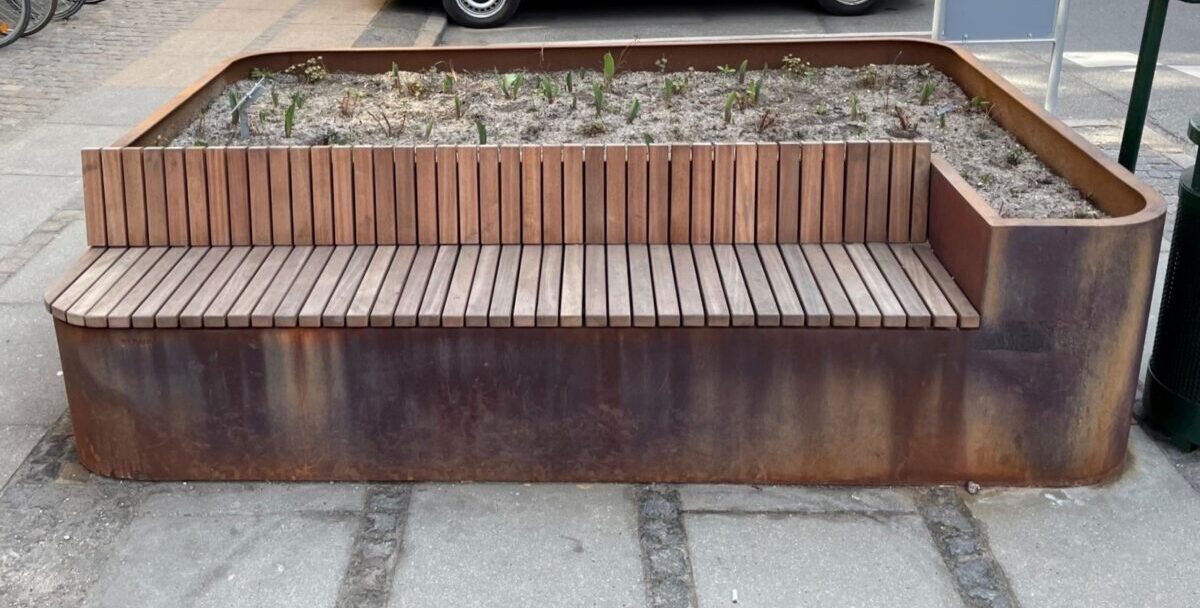 Plantekasser i cortenstål med indbyggede bænke og plads til planter, placeret på Frederiksberg