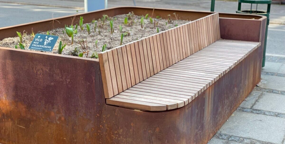 Plantekasser i cortenstål med indbyggede bænke og plads til planter, placeret på Frederiksberg