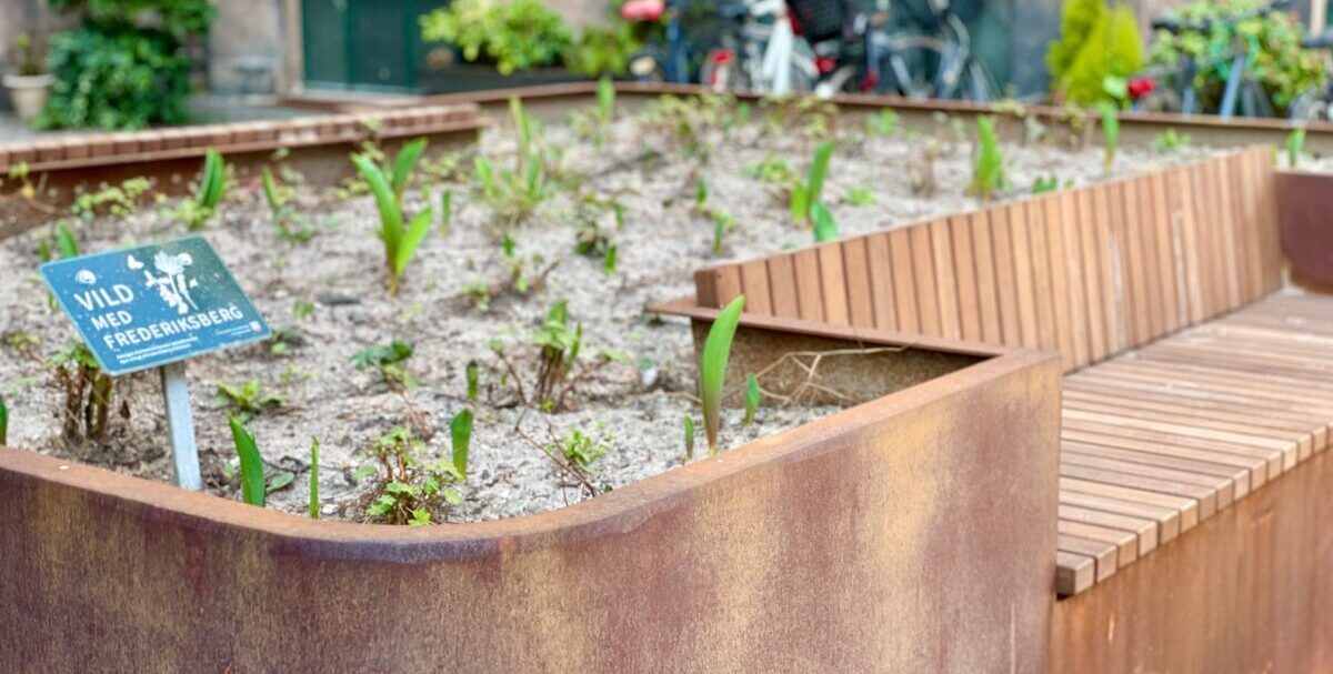 Plantekasser i cortenstål med indbyggede bænke og plads til planter, placeret på Frederiksberg