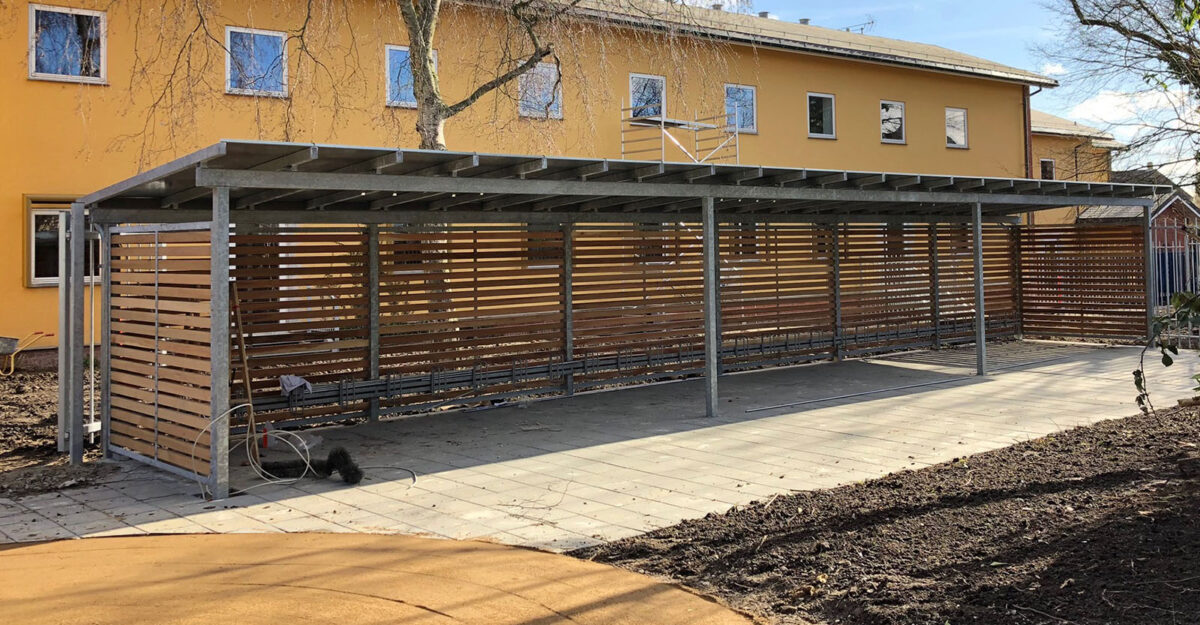 CASA 33 – Cykelskur og miljøstation i én løsning i galvaniseret stål med hårdttræ beklædning og zink tag,