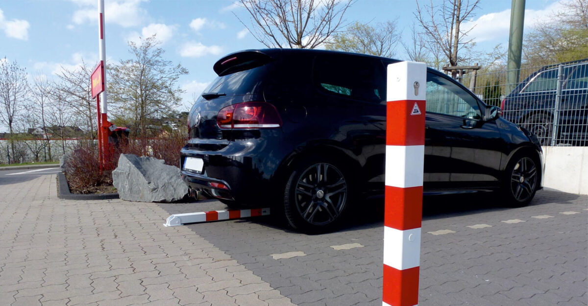 Firkant vippe pullert i malet udførsel og med røde reflekser placeret på parkeringsplads
