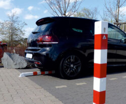 Firkant vippe pullert i malet udførsel og med røde reflekser placeret på parkeringsplads