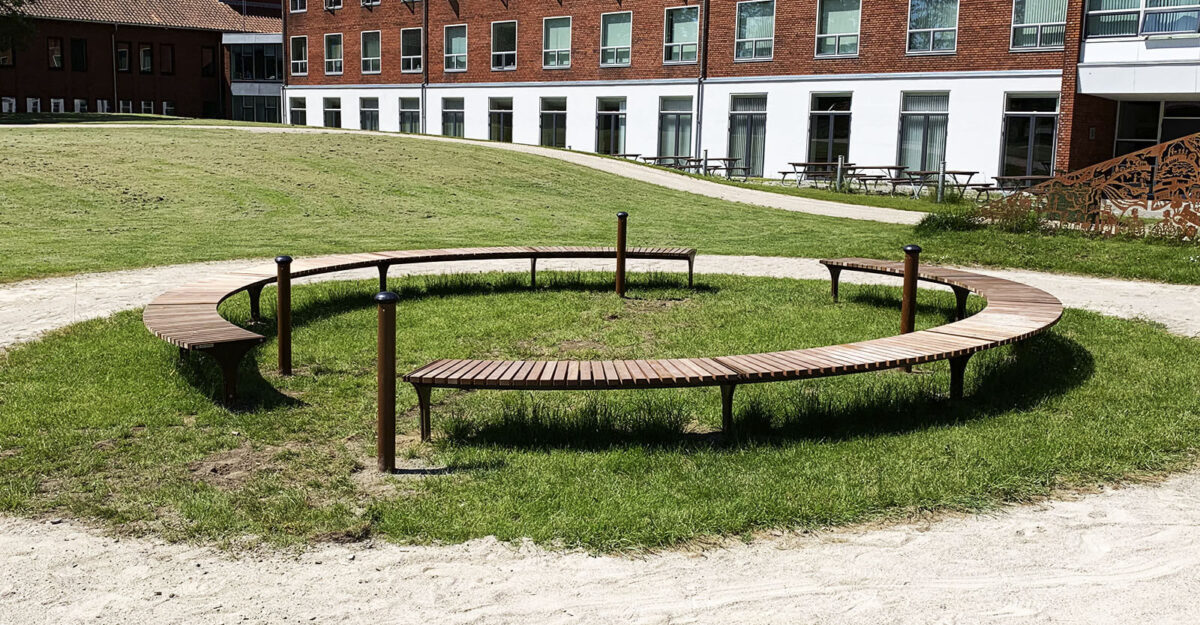 en cirkelbænk i galvaniseret stål og beklædt med mahogni stave i Odders Vitapark